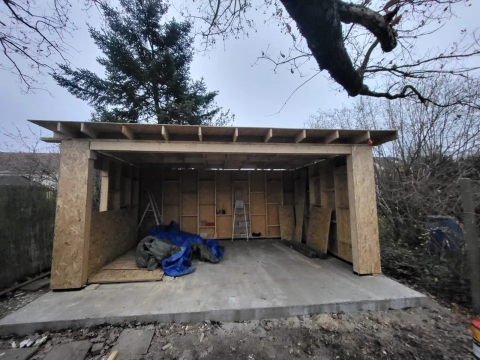 Structure en ossature bois du studio sur sa dalle en béton, poteaux habillés de panneaux OSB et solives de toiture posées