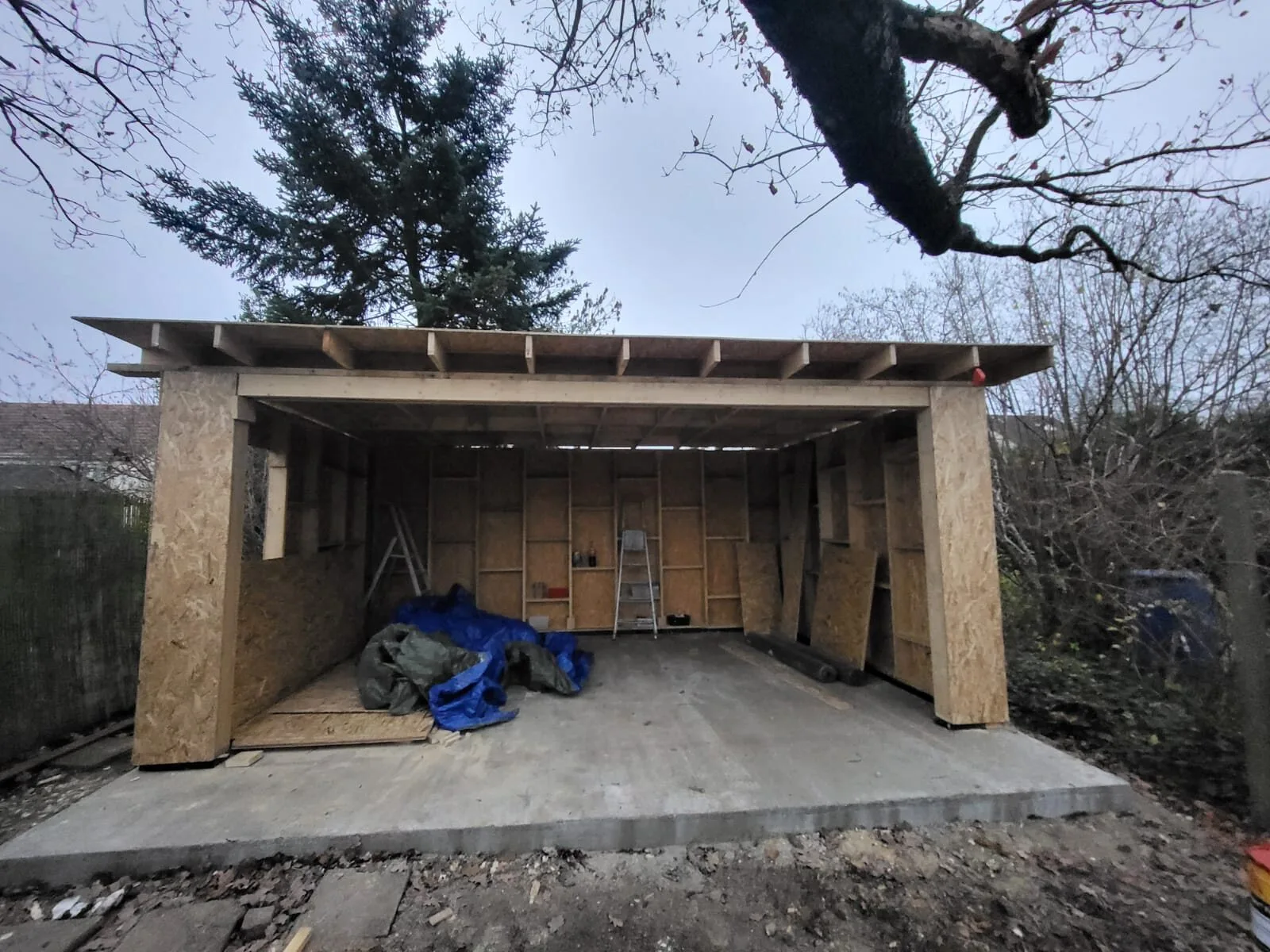 Structure en ossature bois du studio sur sa dalle en béton, poteaux habillés de panneaux OSB et solives de toiture posées