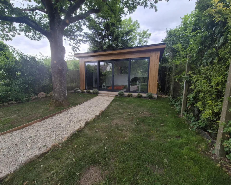 Le studio au fond du jardin, derrière un grand arbre, au bout d’une allée gravillonnée bordée de bois
