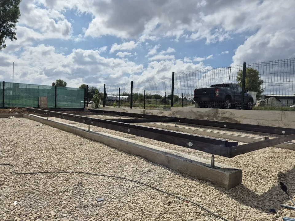 Châssis métallique posé sur des longrines en béton et des vérins réglables, base de la tiny house avant l’ossature