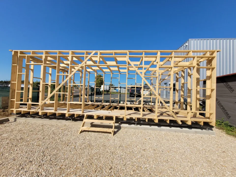 Ossature bois complète avec ses contreventements en diagonale, montée sur son châssis avant la pose des panneaux