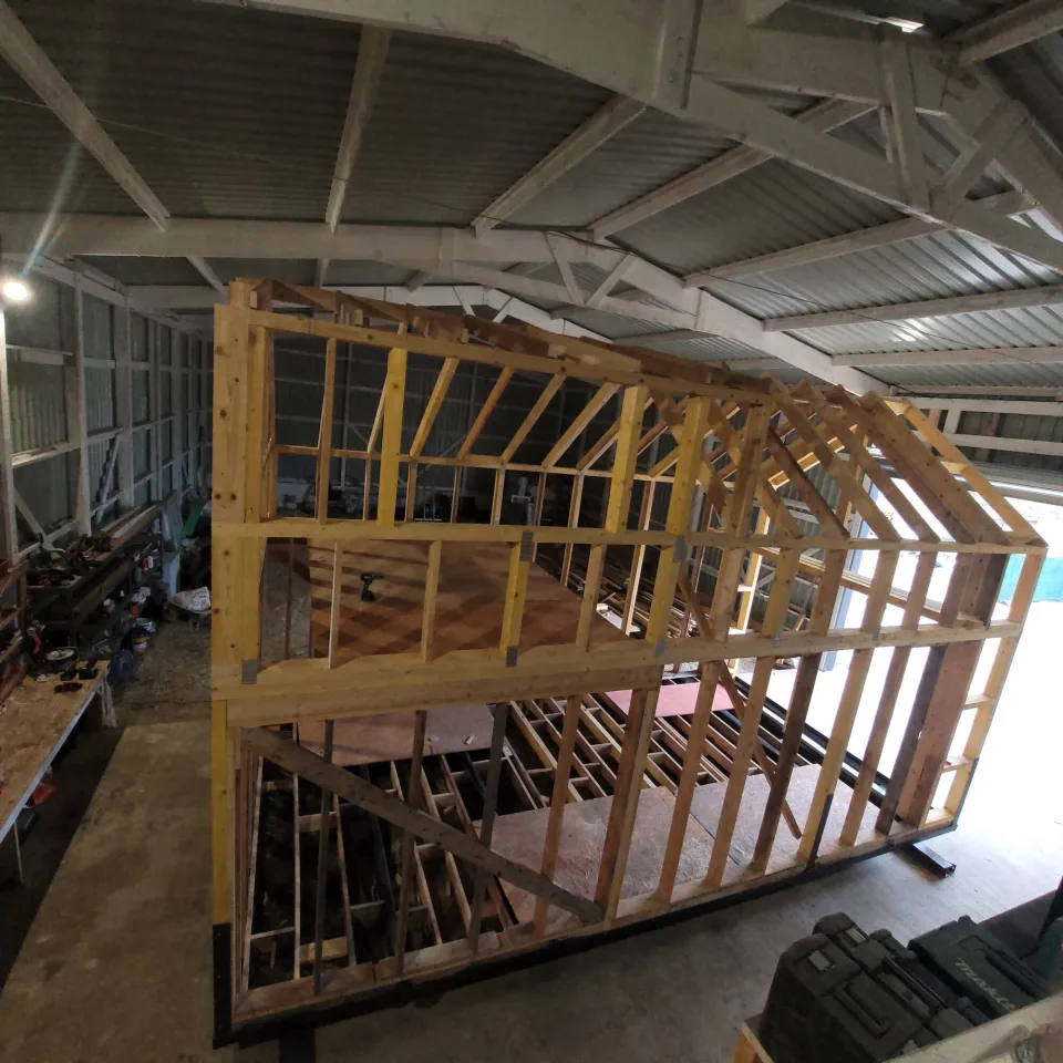 Vue plongeante sur l’ossature, plancher de la mezzanine posé et solives du rez-de-chaussée encore apparentes