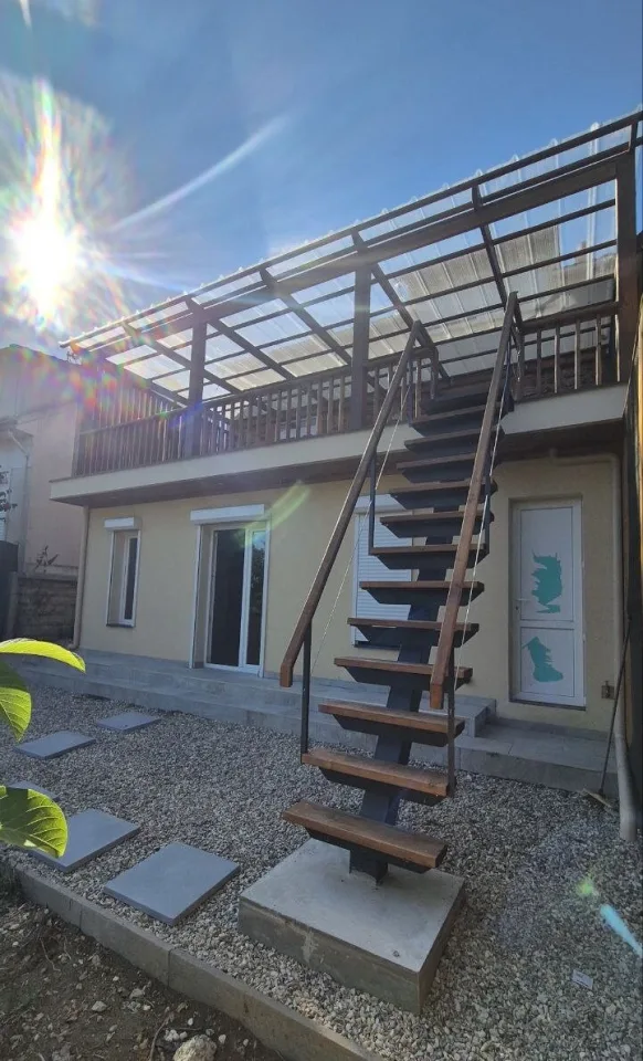 L’escalier et la terrasse au soleil, pas japonais dans le gravier devant l’extension
